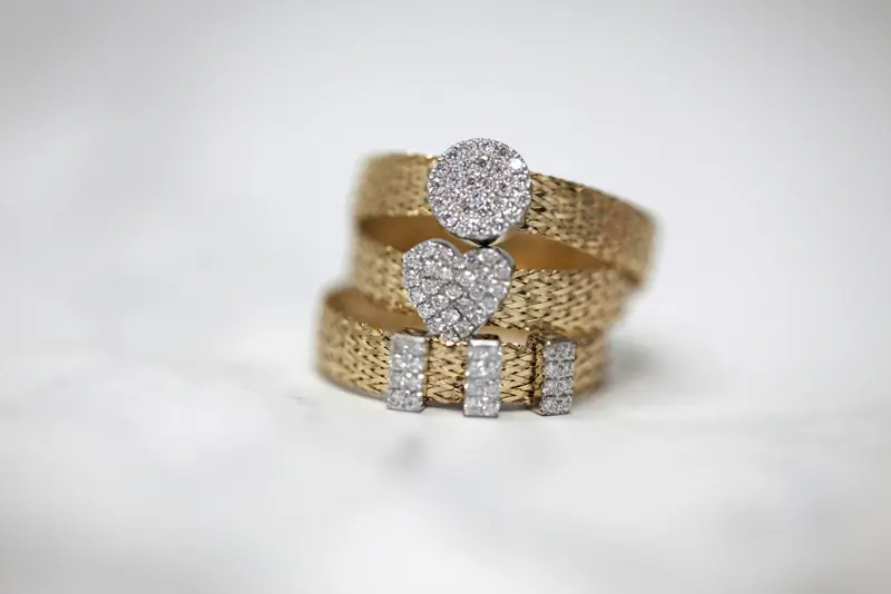 Stack of three gold rings with diamond pavé accents