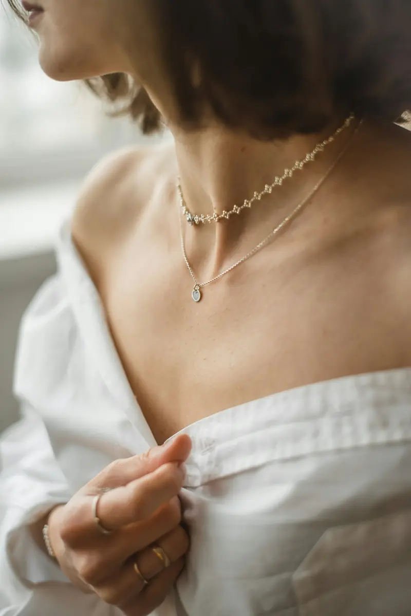 Woman wearing a delicate gold Maison Aurel necklace