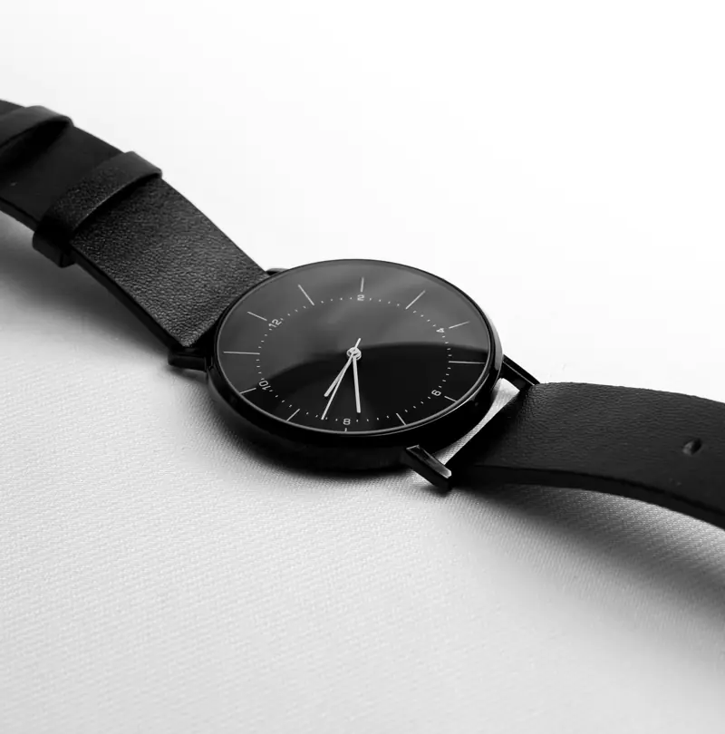 Black-dial minimalist watch on black leather strap